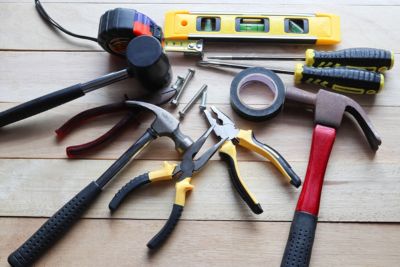 Outils de construction et bricolage de seconde main disposés sur une table.